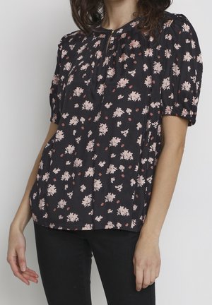Blouse noire à manches courtes avec imprimé floral en rose et rouge, présentant un col froncé et une coupe légèrement ample. Tissu doux et léger.