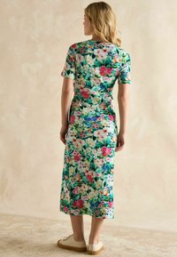 Blumenmusterkleid in lebhaften Farben wie Grün, Pink und Blau. Kurzärmlig, schmal geschnitten und knielang mit glatter Textur.