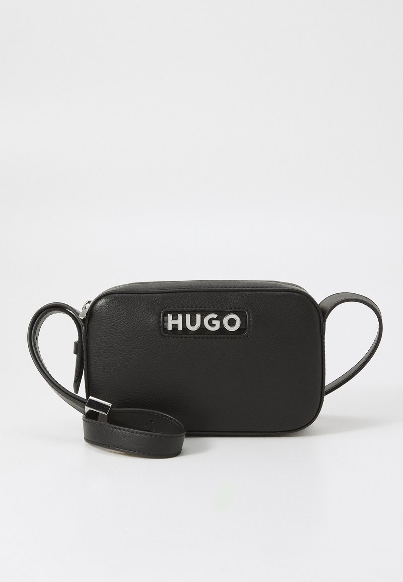 Svart lær rektangulær bag med en sølv "HUGO"-logo, glidelås lukking og avtakbar stropp for allsidige bæringsalternativer.