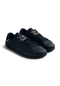 Zapatillas de cuero negro con superficie texturizada, que cuentan con cordones de estampado de leopardo y un diseño elegante. Perfil bajo con punta redondeada y acentos mínimos.