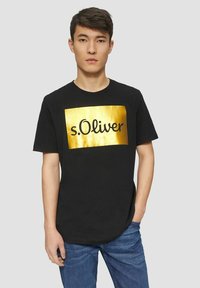 Schwarzes Baumwoll-T-Shirt mit einem goldenen rechteckigen Logo, auf dem der Text "s.Oliver" in Schwarz steht. Kurzärmlig und mit geradem Saumdesign.
