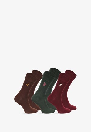 Cztery pary skarpetek w kolorach brązowym, zielonym i burgundowym. Każda para ma mały emblemat zwierzęcia wyszyty w kontrastowych kolorach. Miękka tekstura.