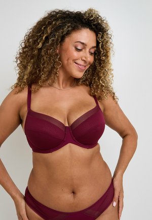 Reggiseno imbottito color malva con dettagli in rete trasparente, motivo testurizzato e spalline regolabili. Accompagnato da uno slip coordinato.