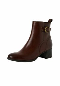 Bota de cuero marrón hasta el tobillo con punta redondeada, tacón de bloque de altura media y un detalle decorativo de hebilla en el lateral. Textura suave, diseño minimalista.