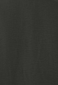 Tissu noir texturé avec une surface légèrement froissée, tissé avec une finition mate, présentant des variations subtiles de ton.