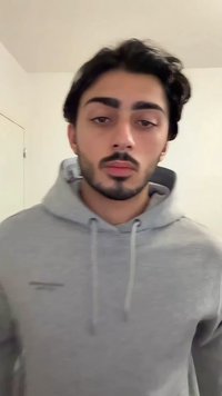 Sweat à capuche gris avec cordon de serrage, comportant un petit logo sur la poitrine. Tissu lisse, coupe décontractée, et capuche doublée. Fond uni.