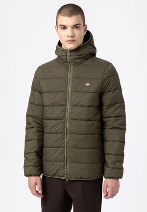 Chaqueta acolchada de color verde oliva con capucha, que presenta una cremallera frontal completa, costuras horizontales y un pequeño logotipo en el lado izquierdo del pecho.
