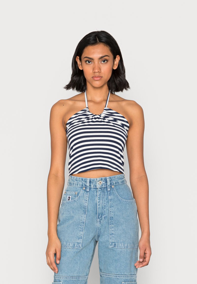 Top de halteres listrado em tecido canelado azul-marinho e branco; design cropped. Combinado com calças cargo de denim azul-claro de cintura alta com bolsos.