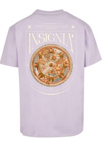 Šviesiai violetinė medvilninė marškinėliai su centriniu apvaliu motyvu, kuriame yra sudėtingos iliustracijos ir auksinės spalvos tekstas "INSIGNIA" virš piešinio.