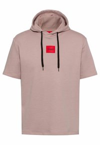 Felpa a maniche corte rosa polveroso con lacci neri e una toppa rossa con l'etichetta "HUGO" al centro del petto.