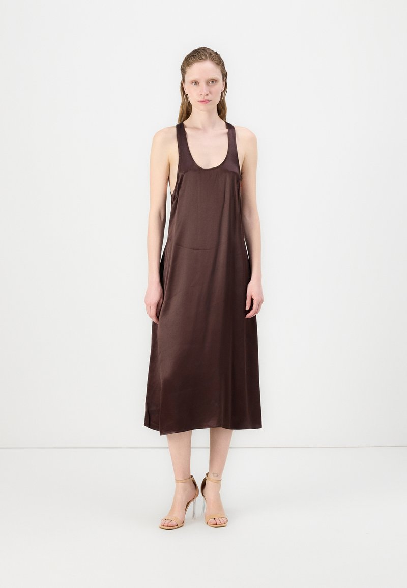 Ermeløs, brun satindress med rund hals og subtile sidespalter, som faller til midt på leggen, pyntet med nude høye hæler.