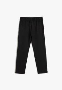 Zwarte leggings gemaakt van zachte, elastische stof. Ze hebben een slank ontwerp met een elastische tailleband en geen opvallende versieringen.