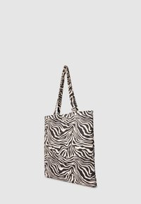 Borsa a tracolla con motivo zebratato in nero e crema. Realizzata in tessuto texturizzato con due manici robusti e una forma rettangolare spaziosa.