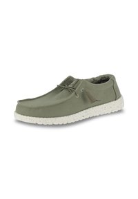 Scarpe casual verde oliva con tomaia in tela, punta rotonda e suola bianca con macchie. Presentano un semplice design con lacci e una caviglia imbottita.