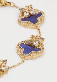 Gouden armband met afwisselend onregelmatige blauwe emaille en schakelaccenten met heldere stenen, met ingewikkelde bloemenmotieven en een sluiting.