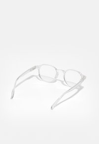 Ochelari cu ramă transparentă și lentile rectangulare, având brațe subțiri și detalii subtile la balamale. Materialul transparent conferă un aspect ușor.