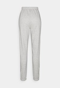 Grå mjukisbyxor med resår i midjan, avsmalnande muddar och ett mjukt, texturerat tyg. Inga fickor eller tydliga mönster syns.