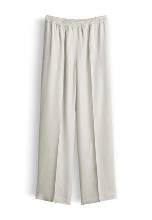 Pantaloni larghi in beige chiaro con vita elastica, tessuto liscio e orli dritti, esposti su sfondo bianco.