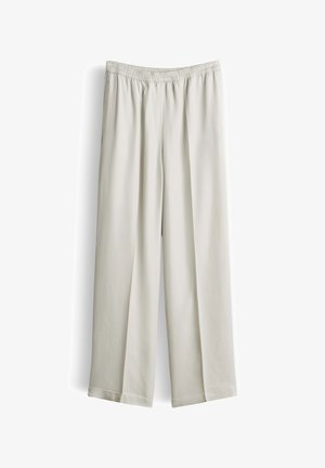 Pantaloni larghi in beige chiaro con vita elastica, tessuto liscio e orli dritti, esposti su sfondo bianco.