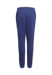 Tummansininen urheiluhousut, joissa on joustava vyötärö ja valkoiset sivuraidat, nilkoissa käänteet valkoista taustaa vasten.