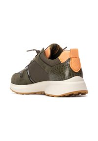 Zapatilla verde oliva con acentos de ante y patrón texturizado de cocodrilo. Cuenta con una suela blanca, una pestaña en el talón beige y cordones marrones.