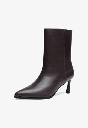 Tamsiai rudos odos kulkšnies batai su smailiu noseliu ir siauru vidutinio aukščio kulnu, lygiu ir glotniu paviršiumi, šono siūlės detalė.