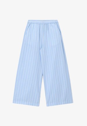 Pantalon large bleu clair à rayures blanches verticales, taille élastique et poches latérales, conçu pour un usage décontracté.