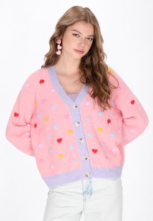 Roze cardigan met meerkleurige hartpatronen, een lila kraag en knopen aan de voorkant. Zachte textuur, losse pasvorm en geribde manchetten en zoom.