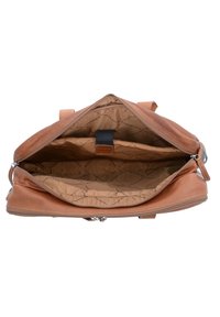 Bolso de cuero marrón con parte superior abierta, que muestra un interior espacioso forrado con tela beige, que cuenta con múltiples compartimentos y una textura suave.