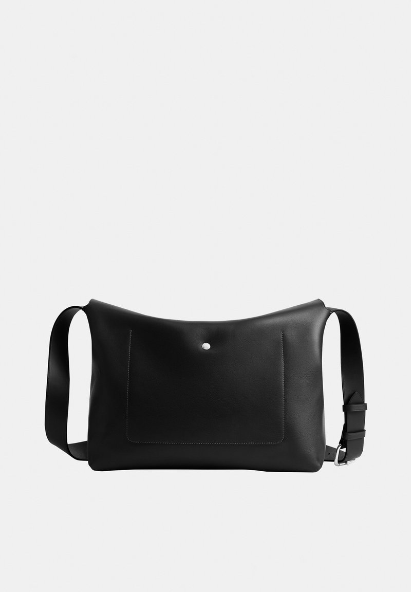 Zwarte leren schoudertas met verstelbare riem, voorvak met klep en zilveren knoopsluiting, geplaatst tegen een effen witte achtergrond.