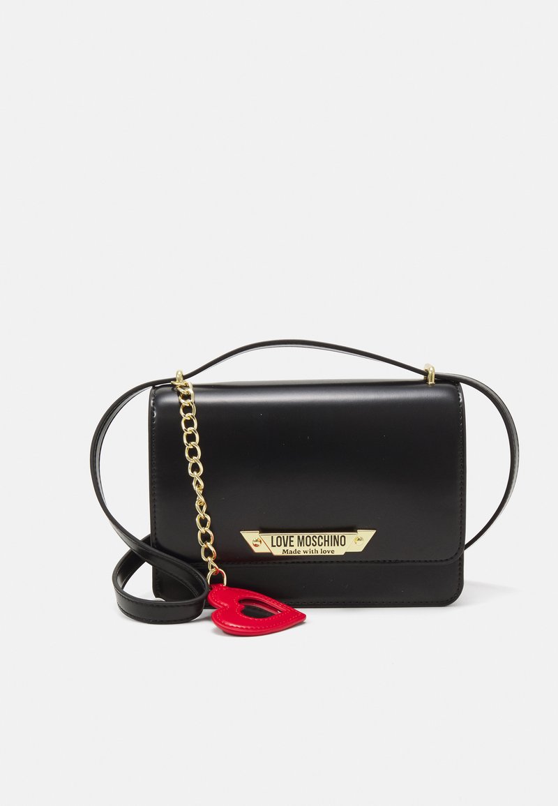 Borsa a tracolla in finta pelle nera con catena e tracolla dorate, dotata di una placca con logo dorato e un ciondolo a forma di cuore rosso.