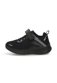 Zapatilla deportiva negra con parte superior de malla, correa ajustable y cierre de cordones. Presenta acentos grises y una suela de goma texturizada.