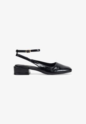 Zapato slingback negro de charol con punta afilada, correa ajustable en el tobillo y un tacón bajo tipo bloque. Textura suave y acabado brillante.