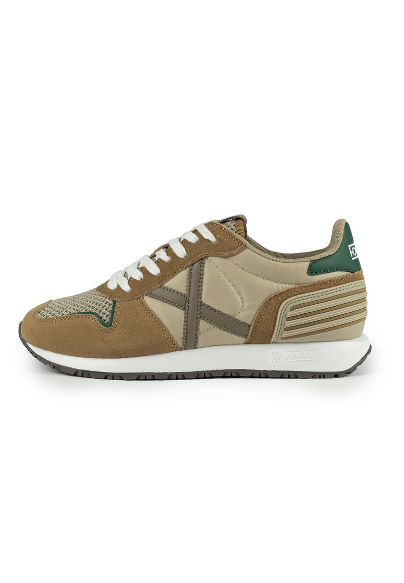 Beige and brown athletic sneakers with suede and mesh materials, white laces, green accents, textured side detailing, and rubber sole.