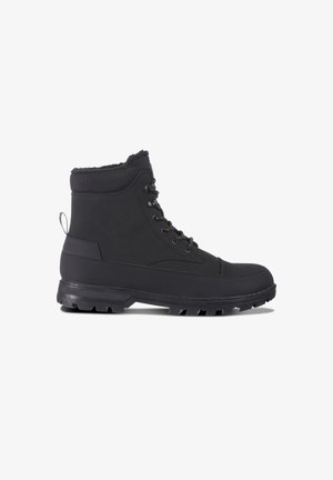 Schwarze wasserdichte Stiefeletten mit einer strukturierten Oberfläche, einem gemusterten Stoffbund, metallischen Ösen und einer robusten Gummisohle für guten Halt.