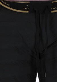 Zwarte gewatteerde shorts met een elastische tailleband, voorzien van een gouden streep en zwarte trekkoorden. Gladde textuur, minimalistisch design.