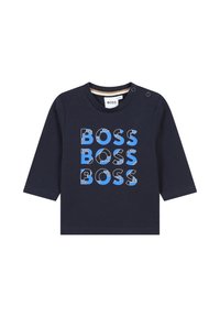 Chemise à manches longues navy en coton avec un texte "BOSS" en bleu et blanc, audacieux et multicolore. Fermeture par boutons pression à l'épaule.