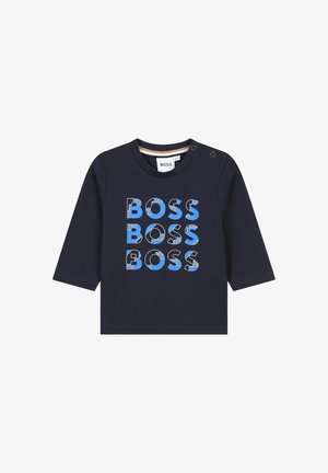 Chemise à manches longues navy en coton avec un texte "BOSS" en bleu et blanc, audacieux et multicolore. Fermeture par boutons pression à l'épaule.