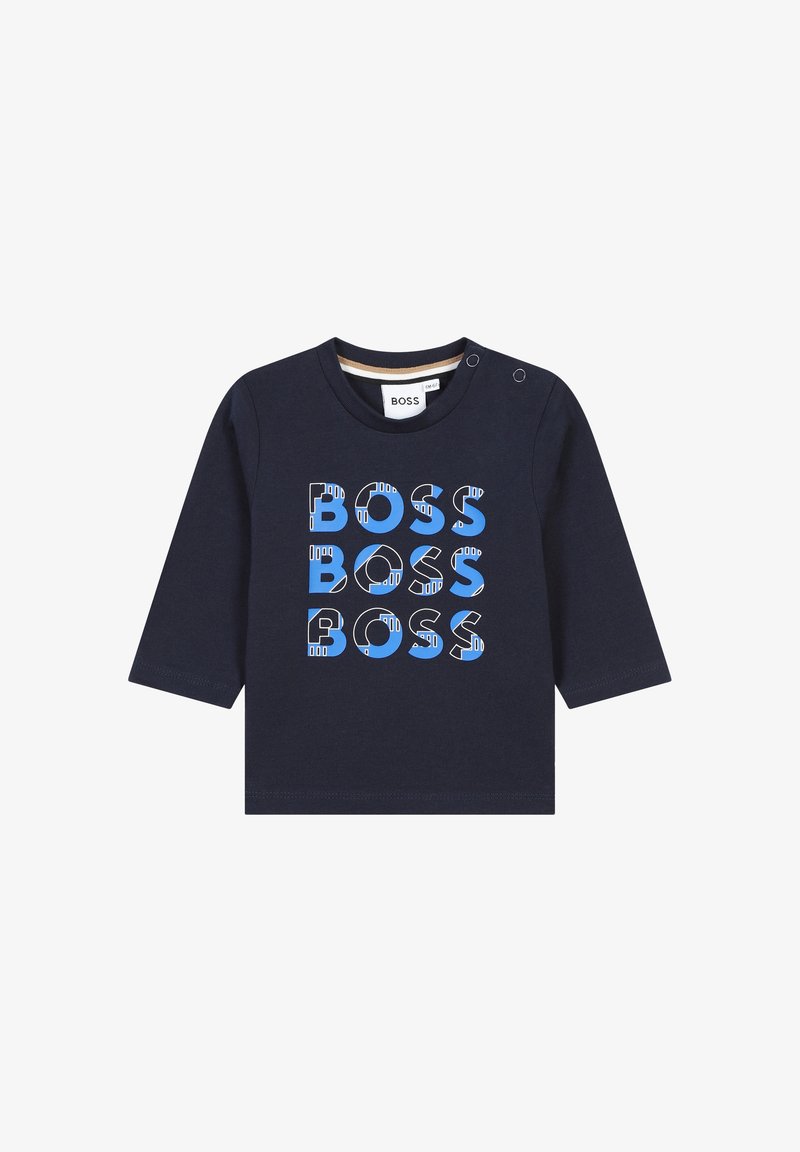 Chemise à manches longues navy en coton avec un texte "BOSS" en bleu et blanc, audacieux et multicolore. Fermeture par boutons pression à l'épaule.