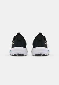 Zapatillas deportivas negras con parte superior texturizada, media suela blanca y suela negra. Detalles reflectantes dorados en los lados y lazo en la parte posterior.