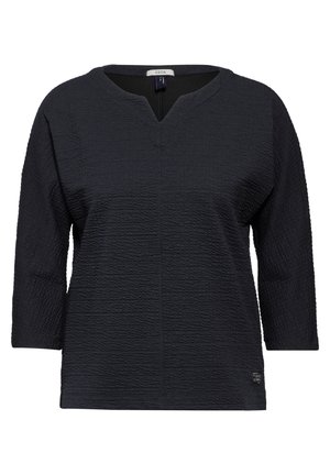 Černý texturovaný top s výstřihem do V, tříčtvrtečními rukávy a jemným mřížkovým vzorem. Materiál vypadá lehce a mírně elasticky.