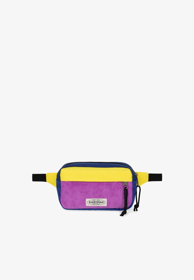 Riñonera multicolor en tela de pana morada, amarilla y azul. Cuenta con un bolsillo frontal con cremallera y una correa ajustable.