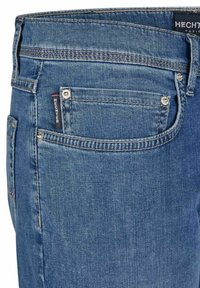 Lichtblauwe denim jeans met een klassieke taperende pasvorm. Kenmerken zijn een klein logo-label, metalen knopen en stiksels op de zakken.