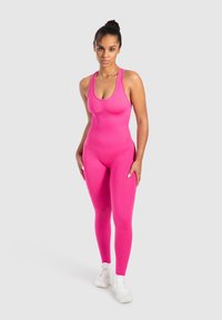 Tight pink one-piece jumpsuit med axelband, tillverkad av stretchtyg, med rundad halsringning och en slät yta.