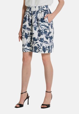 Jupe imprimée florale en bleu marine et blanc, dotée d'une taille élastique et de poches latérales, fabriquée en tissu léger avec une finition texturée.