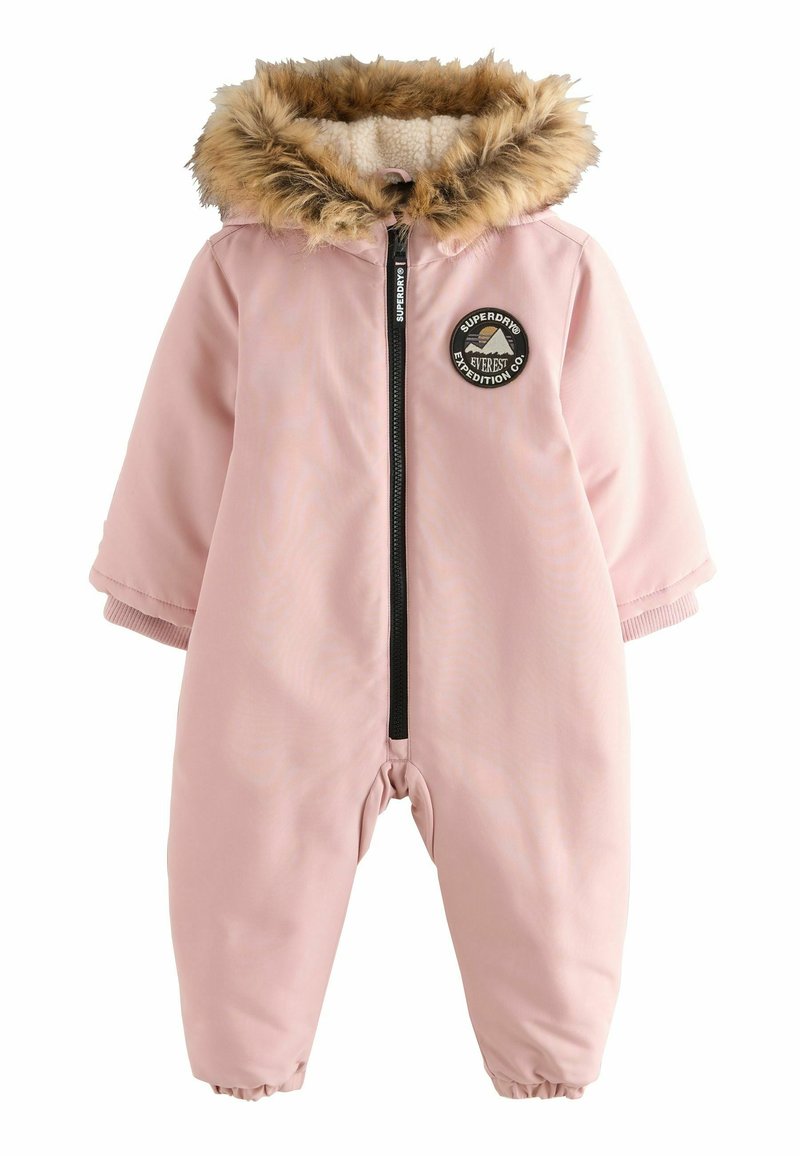 Mono de nieve rosa con capucha de pelo sintético, cremallera frontal, puños acanalados y un diseño de insignia circular que presenta una montaña y texto. Exterior suave.