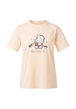 Beige T-shirt med en tegneserie-kanin med hovedtelefoner, der holder en bamse, noder, et krus og teksten Music Rabbit Day.