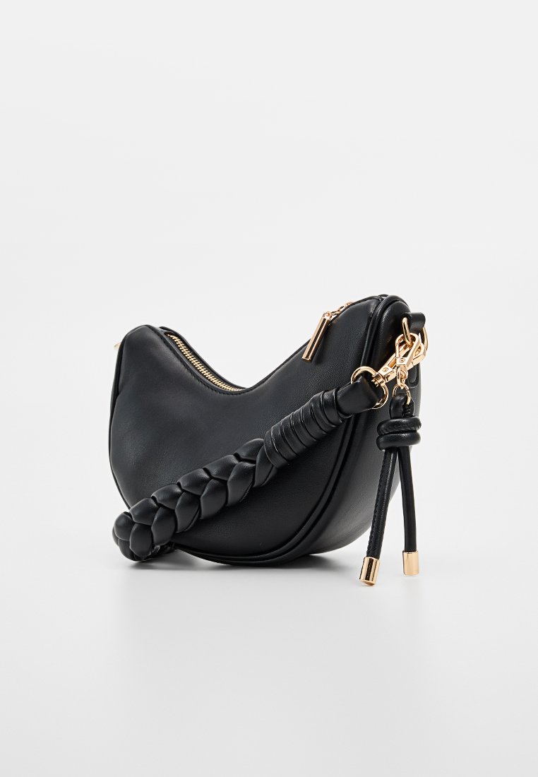 Zwarte leren handtas met een gebogen vorm, gevlochten hengsel, gouden hardware en ritssluiting. Gladde textuur met minimale details.