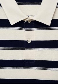 Bavlnené polo tričko s horizontálnymi pruhmi námorníckej modrej a krémovej farby, s klasickým golierom a zapínaním na tri gombíky. S textured textúrou.