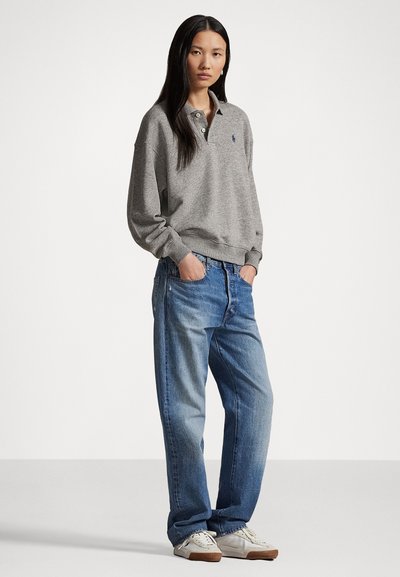 Hall hallina puuvillane polo-sweater pehme tekstuuriga, mugav lõige ja soonikkoes mansetid. Kombineeritud lõdva lõikega siniste denimiste teksade ja valgete spordijalatsitega.